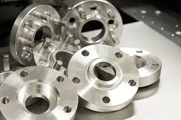 A photograph where you can see six metal pieces of threaded flanges that are used to make resistant industrial joints.