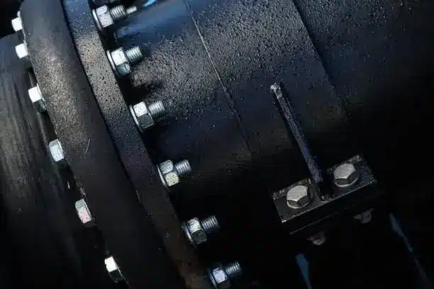 A black flange attached to a large black pipe, commonly seen in systems involving DIN vs ANSI Flanges: A Comparison of Metric and Imperial Standards